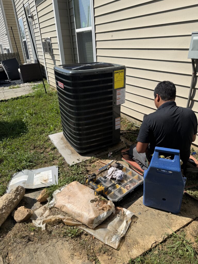 Union HVAC technician servicing a residential heating and cooling system in the Charlotte area